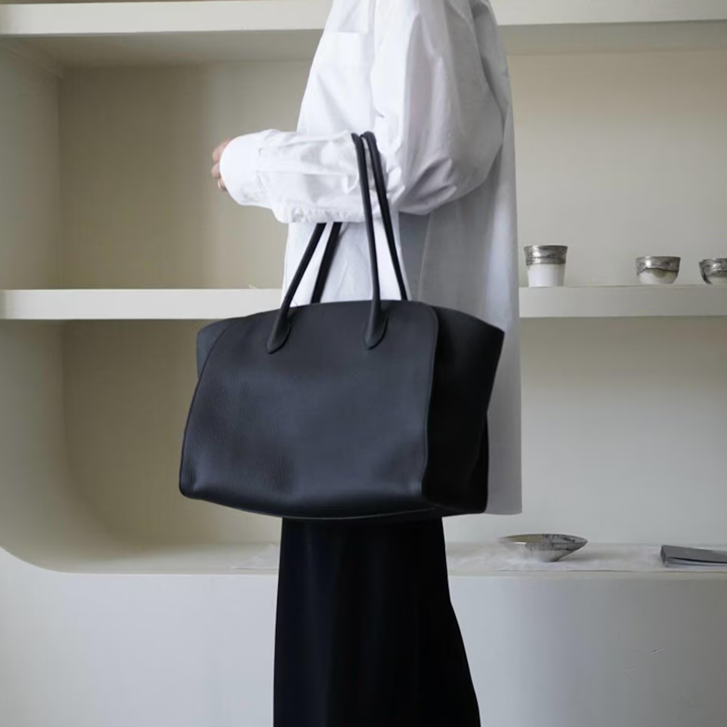 Jet Black Pebbled Grain Flared Side Large Tote With Dual Pairs Elongated Carry Loops, Pointed Stitched Tab Fixtures And Spacious Open Inner Storage Cavity