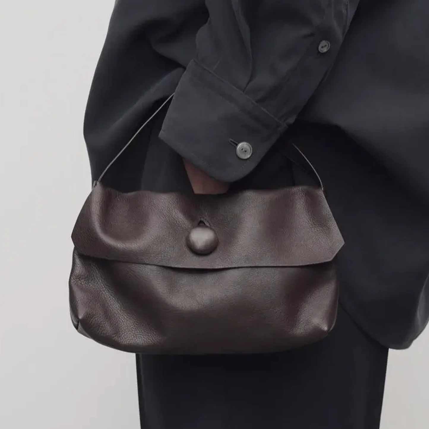 Chocolate Brown Fine Grain Soft Rectangular Mini Handbag With Teardrop Cutout Dome Snap Flap And Slim Curved Single Carry Loop